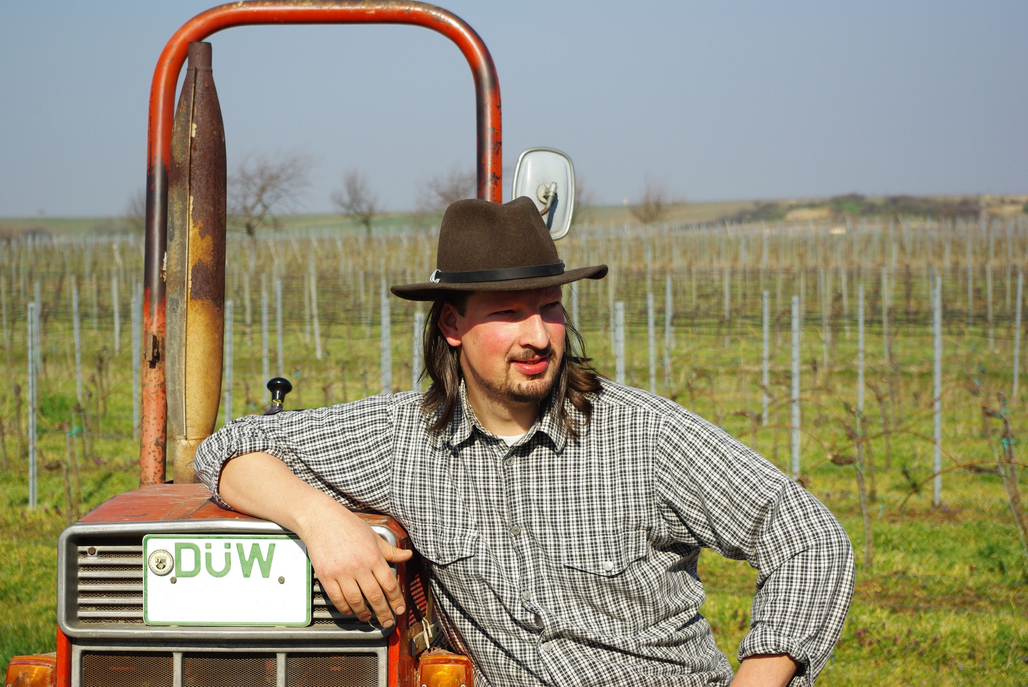 Winzer am Traktor zwischen den Reben